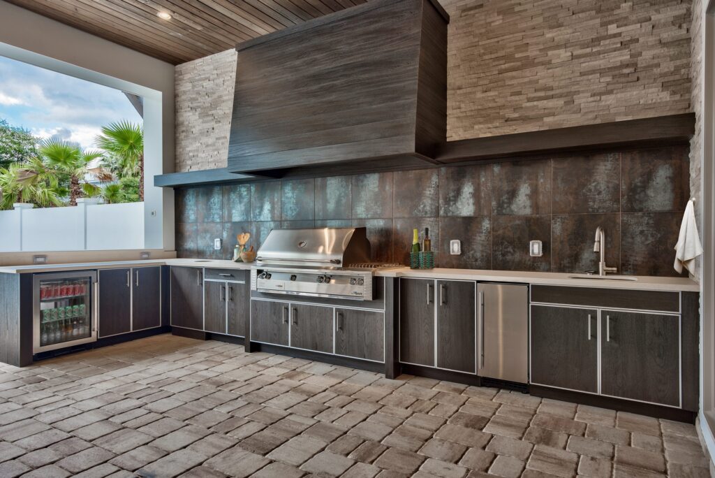 A built-in grill under a custom hood in a NatureKast outdoor kitchen