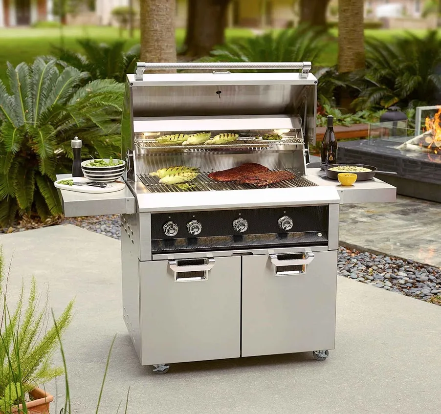 A Hestan freestanding gas grill on a stone patio