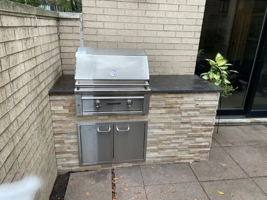 Compact stone outdoor kitchen — prefab island with built-in grill and countertop