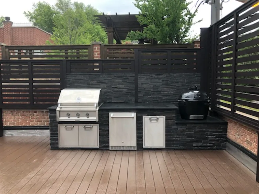 Rooftop stone outdoor kitchen with built-in grill and smoker