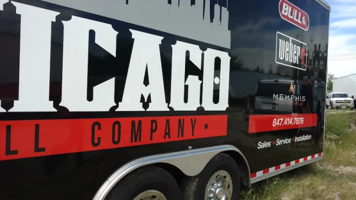 The Chicago Grill Company mobile showroom trailer parked outdoors, wrapped with Bull, Weber, and Memphis branding